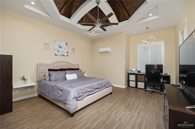 bedroom featuring a wall mounted AC, ceiling fan, and light hardwood / wood-style floors