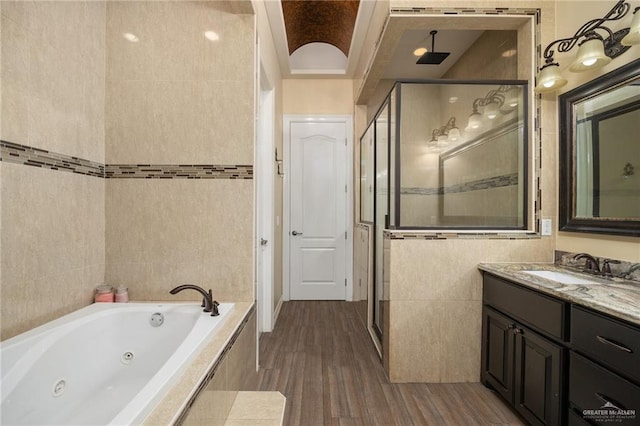 bathroom with hardwood / wood-style floors, vanity, and shower with separate bathtub