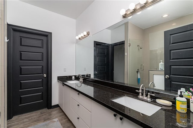 bathroom featuring vanity, hardwood / wood-style flooring, and a shower with shower door