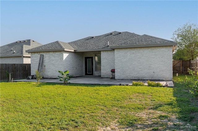 rear view of house with a yard and a patio area