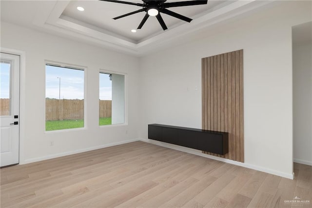 unfurnished room with light wood finished floors, a ceiling fan, and a healthy amount of sunlight