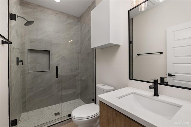 bathroom with vanity, toilet, and a stall shower