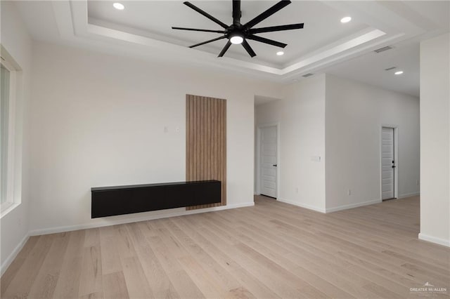 spare room with visible vents, recessed lighting, a ceiling fan, a tray ceiling, and light wood-style floors