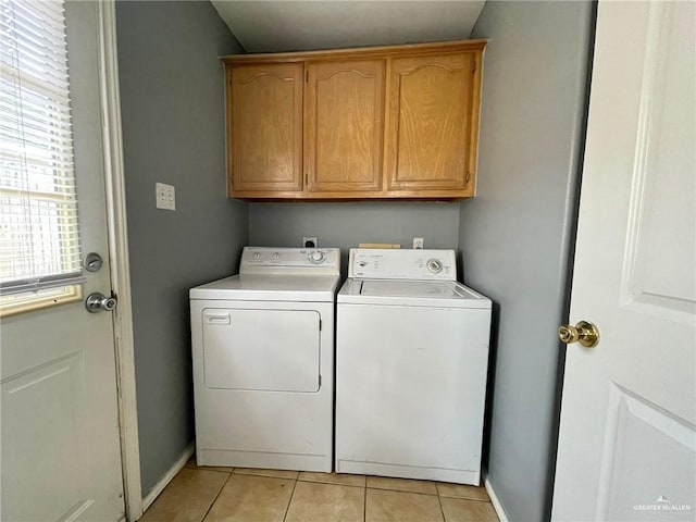 laundry room with cabinet space, light tile patterned floors, baseboards, and separate washer and dryer