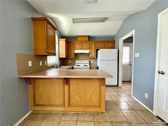 kitchen with a peninsula, white appliances, under cabinet range hood, and light countertops