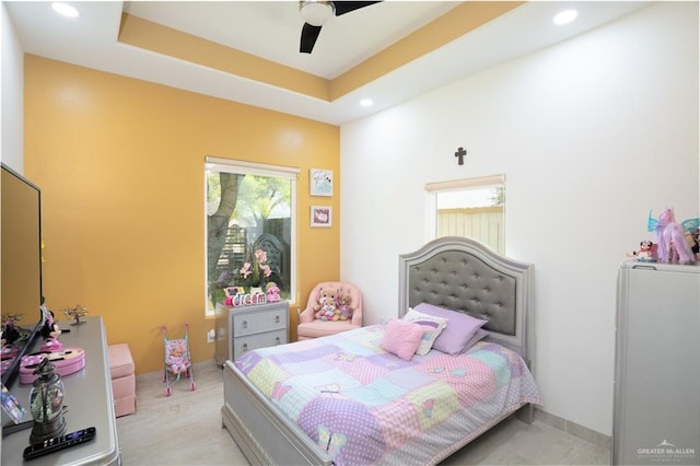 bedroom with ceiling fan and a raised ceiling