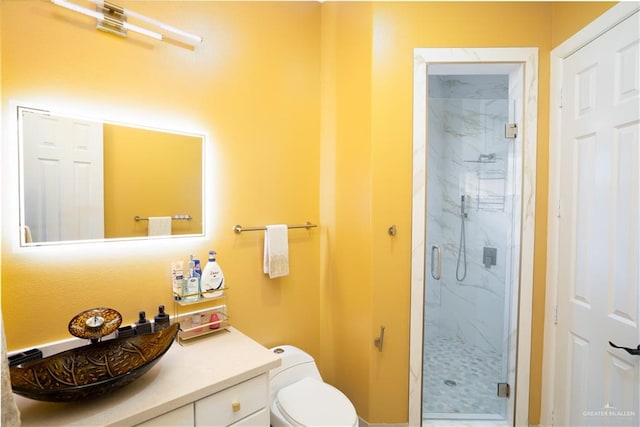 bathroom featuring vanity, toilet, and a shower with shower door