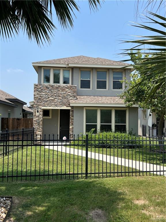 10228 N 14th St, Mcallen, TX 78504 - view of front facade featuring stucco siding, stone siding, a fenced front yard, and roof with shingles
