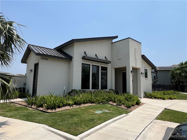 10228 N 14th St, Mcallen, TX 78504 - view of front of home with a standing seam roof, a metal roof, a front lawn, and stucco siding