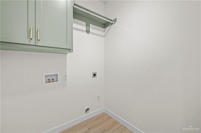 clothes washing area featuring washer hookup, electric dryer hookup, cabinets, and light hardwood / wood-style flooring