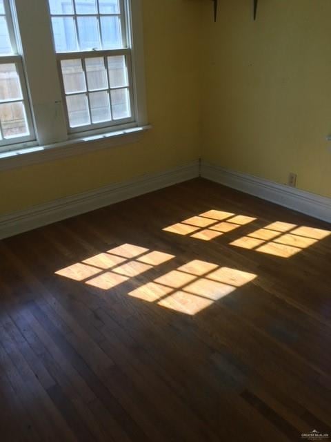 empty room with dark hardwood / wood-style floors