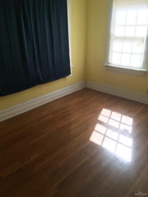 unfurnished room with dark hardwood / wood-style flooring