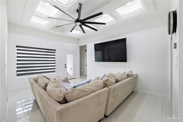living area with baseboards, light tile patterned flooring, a skylight, and ceiling fan