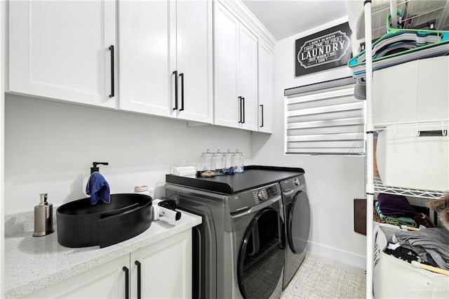 laundry room with baseboards, cabinet space, and washer and clothes dryer