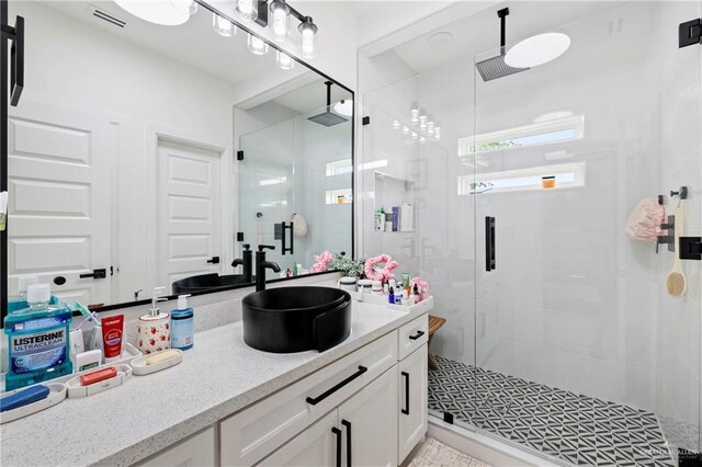 full bathroom featuring visible vents, a stall shower, and vanity