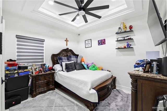 bedroom with ceiling fan and a raised ceiling