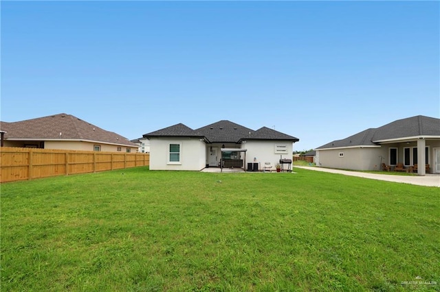 back of house with a yard, fence, central AC unit, and stucco siding