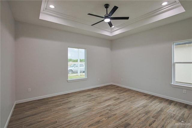 unfurnished room with ceiling fan and a tray ceiling