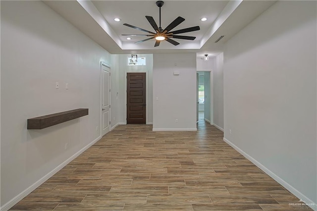 entryway featuring a tray ceiling and ceiling fan