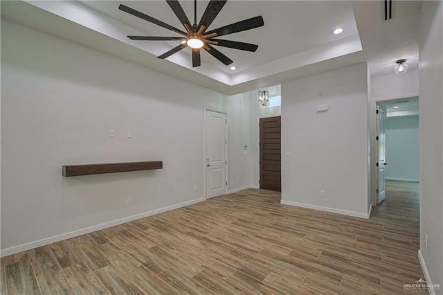 spare room with a raised ceiling and ceiling fan