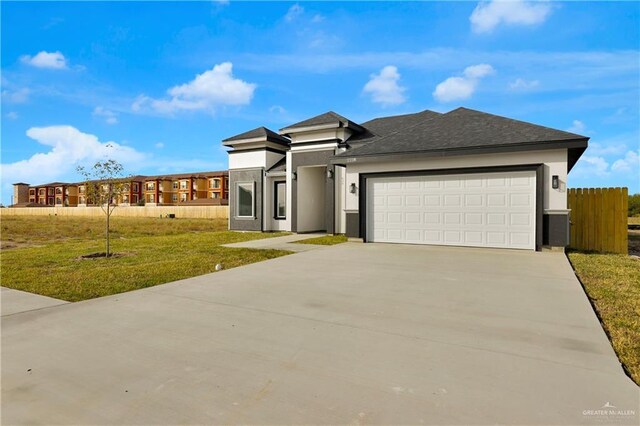 prairie-style home with a garage and a front lawn