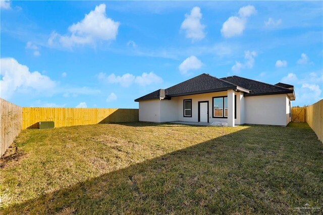 rear view of house with a patio area and a yard