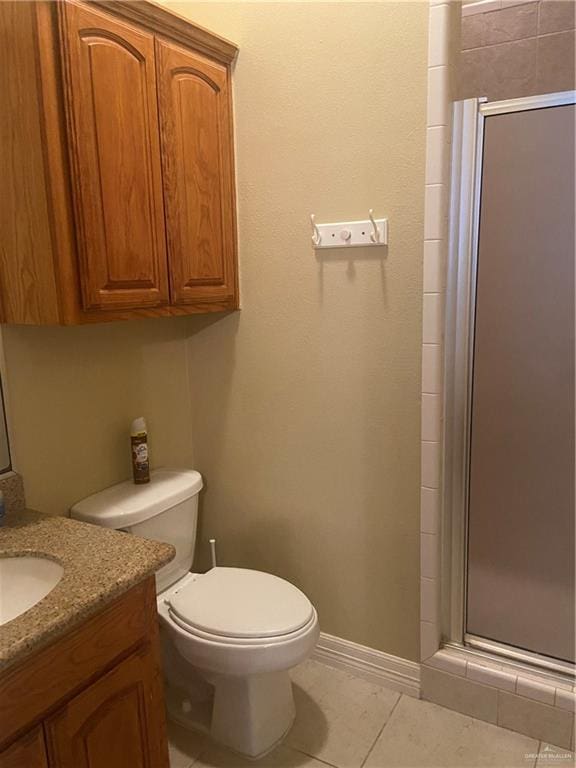 bathroom featuring toilet, vanity, tile patterned floors, and walk in shower