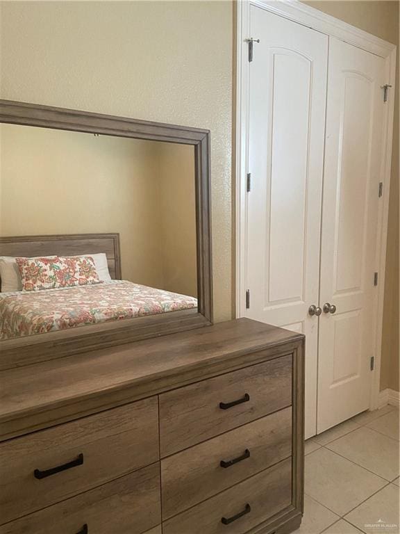 unfurnished bedroom featuring light tile patterned floors and a closet