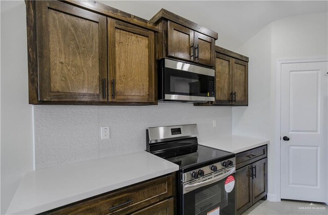 kitchen with light countertops, decorative backsplash, dark brown cabinets, and stainless steel appliances