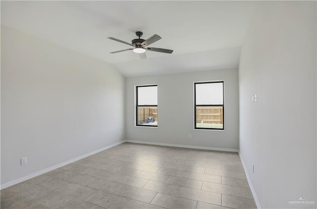 empty room featuring baseboards, ceiling fan, light tile patterned floors, and lofted ceiling