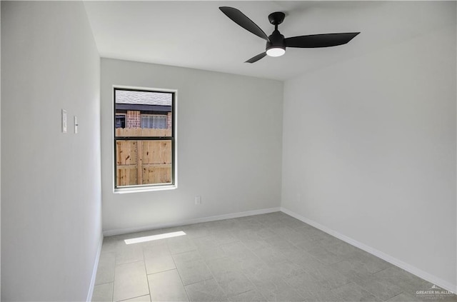 spare room featuring baseboards and a ceiling fan