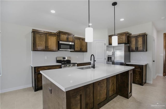 kitchen with light countertops, dark brown cabinetry, appliances with stainless steel finishes, and a sink