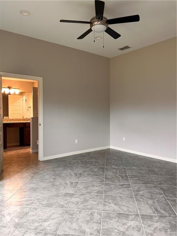 tiled empty room featuring ceiling fan