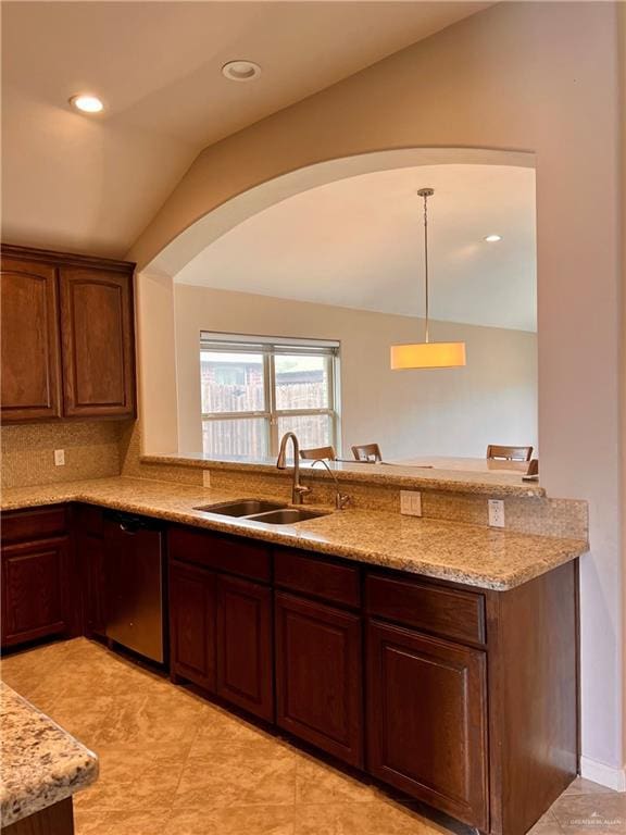 kitchen with sink, light stone counters, stainless steel dishwasher, pendant lighting, and lofted ceiling