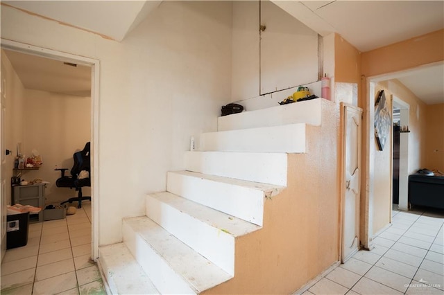 stairway featuring tile patterned flooring