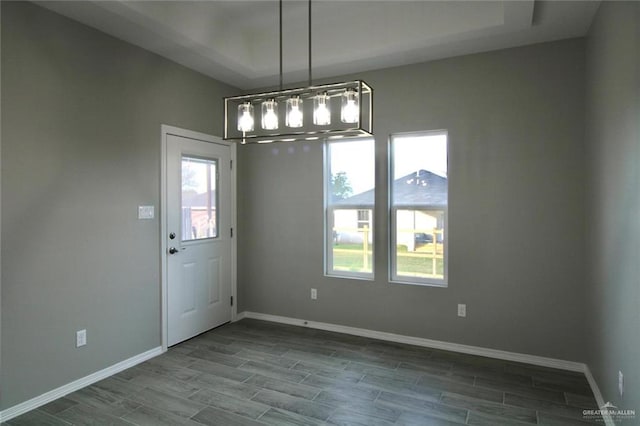 unfurnished dining area featuring a chandelier