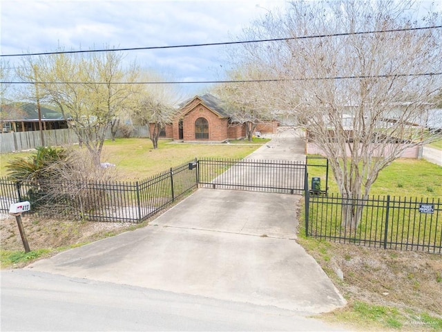 view of front facade featuring a gate, fence, driveway, and a front lawn