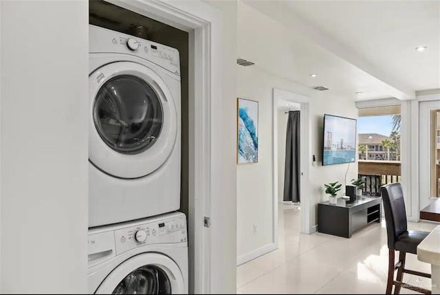 washroom with light tile patterned flooring and stacked washer and clothes dryer