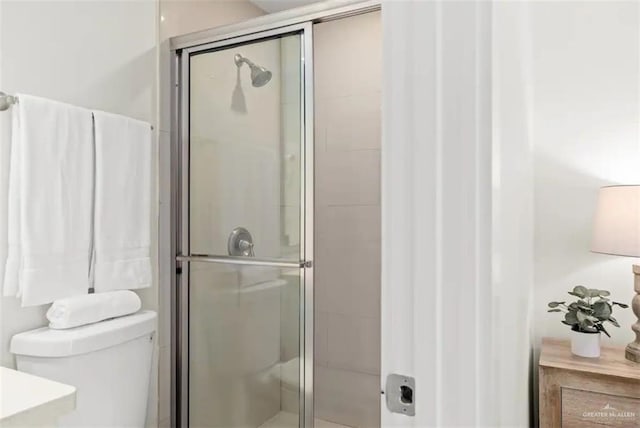 bathroom with an enclosed shower and toilet