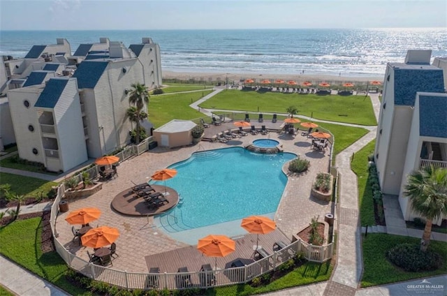 view of pool with a water view, a patio, and a view of the beach