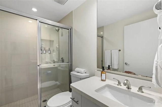 bathroom featuring tile patterned floors, vanity, toilet, and walk in shower