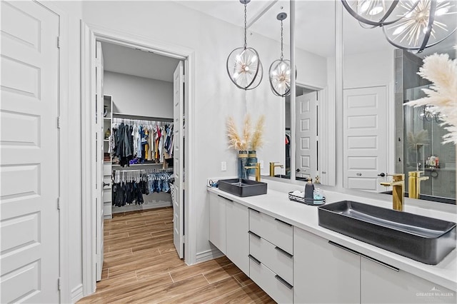 bathroom with hardwood / wood-style flooring, a notable chandelier, and vanity