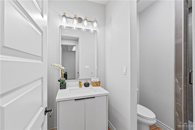 bathroom featuring vanity, toilet, and a shower with shower door