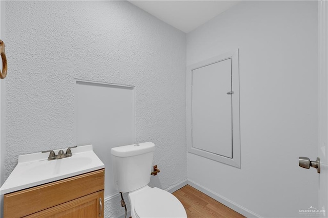 3207 E San Luis Cir, Mission, TX 78573 - bathroom featuring vanity, toilet, wood finished floors, a textured wall, and baseboards