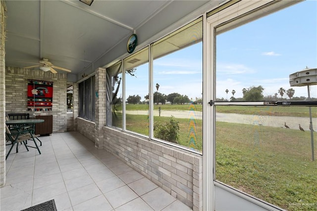 unfurnished sunroom featuring ceiling fan