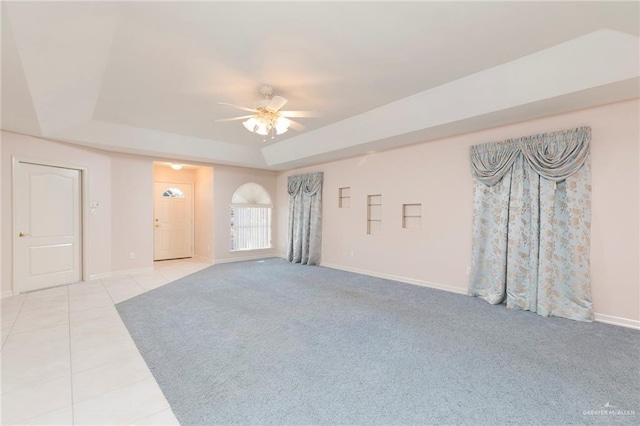 112 Saturn St, Mission, TX 78572 - spare room with a tray ceiling, a ceiling fan, light tile patterned floors, baseboards, and light carpet