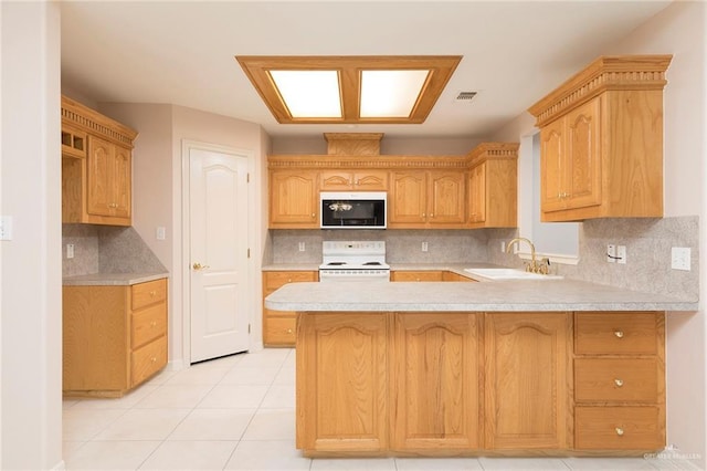 112 Saturn St, Mission, TX 78572 - kitchen featuring a sink, electric range, a peninsula, light countertops, and backsplash