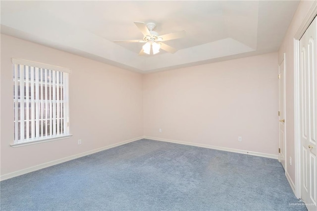 112 Saturn St, Mission, TX 78572 - carpeted spare room with a tray ceiling, a ceiling fan, and baseboards