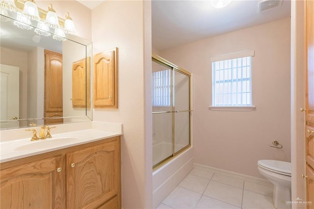 112 Saturn St, Mission, TX 78572 - full bathroom with toilet, vanity, tile patterned floors, combined bath / shower with glass door, and baseboards