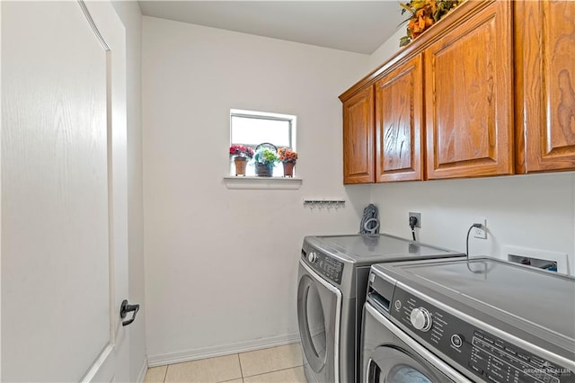 laundry area with light tile patterned flooring, independent washer and dryer, cabinet space, and baseboards